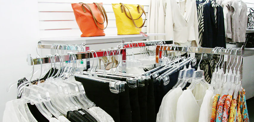 Tienda de ropa donde se exhiben prendas y accesorios en racks para colgar ropa.