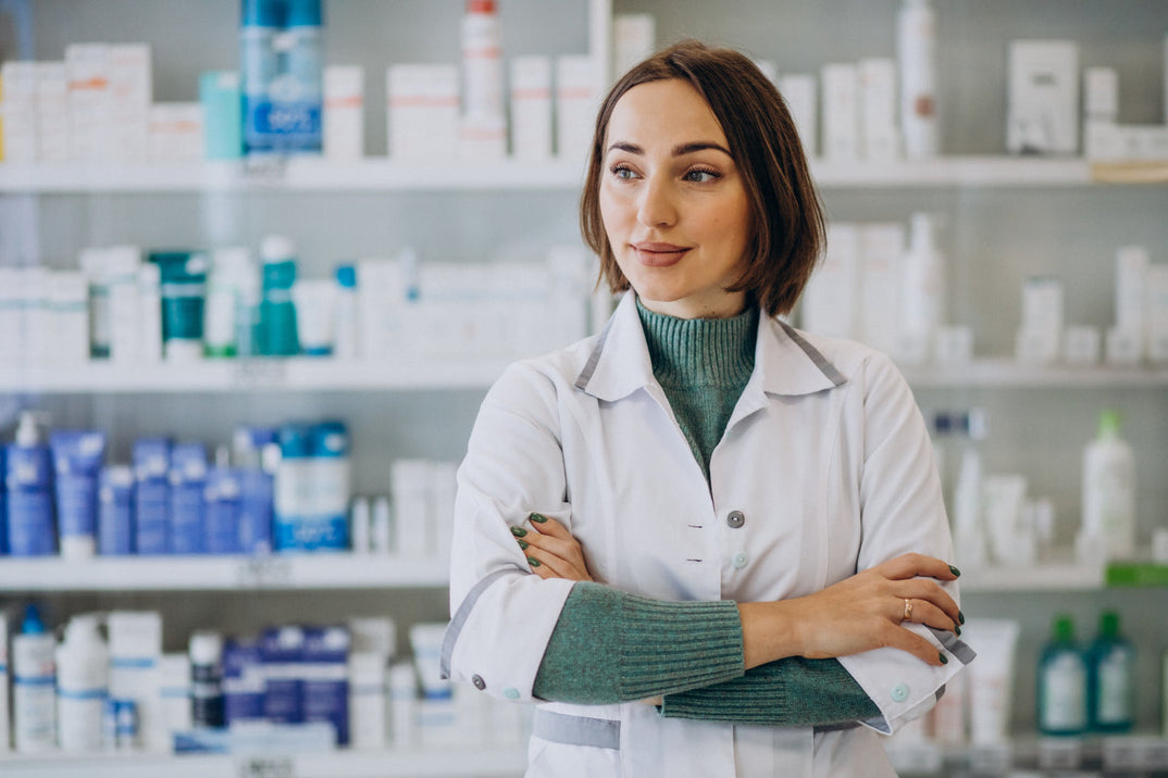 Mujer en farmacia de pie frente a soluciones de exhibición de productos.